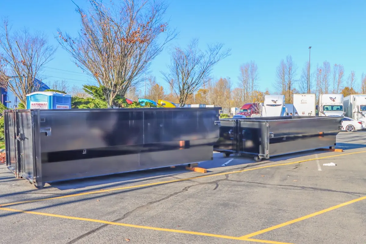 Professional dumpster rental service with roll-off container on residential driveway in Fremont